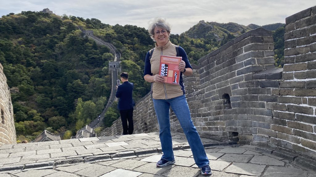 Marilu en la Muralla China con su libro